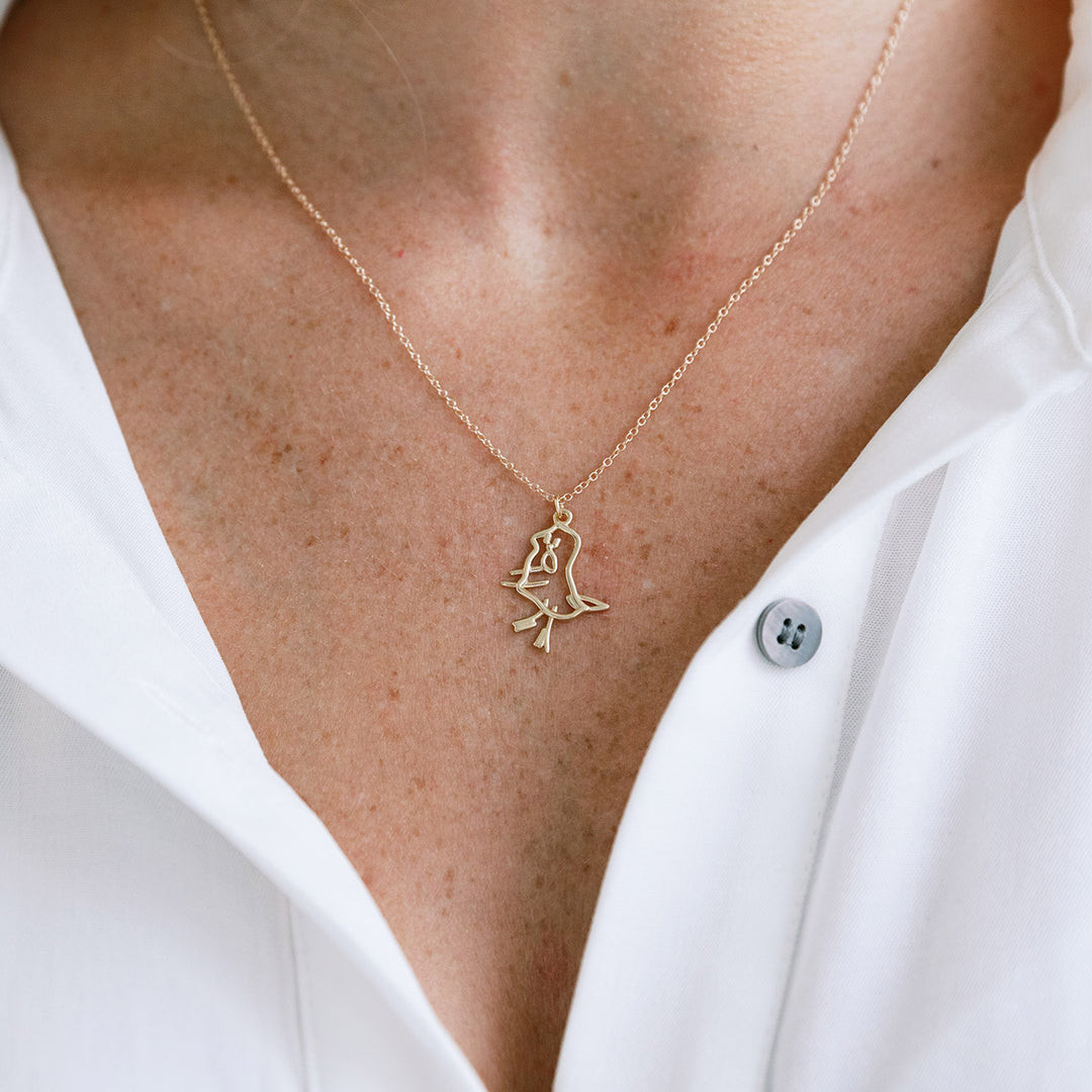 Custom gold necklace with a child’s drawing pendant worn on a model in a white shirt.
